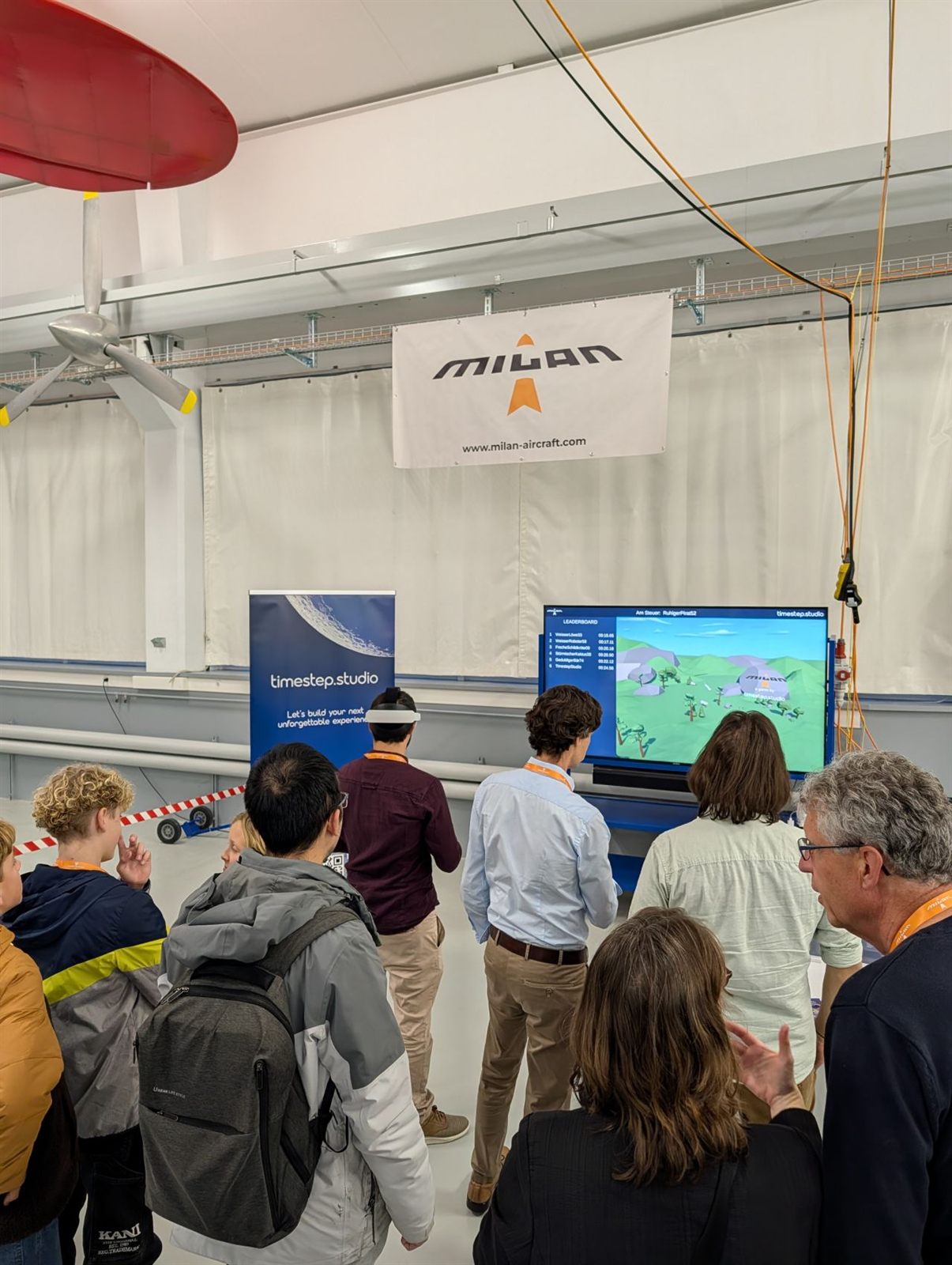 A crowd watching a player's view of VR Lander on a large screen at the Milan Flugzeugwerke event.
